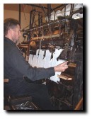 Click for a larger image of Martin Green working the framework knitter in Kirby Muxloe. This is used to create special wraps, shawls, stoles, squares and scaves.